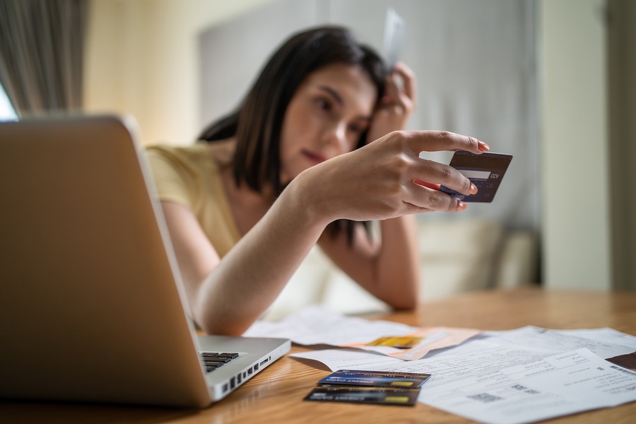 A woman examining a credit card, symbolizing the significance of understanding Credit Card Fraud